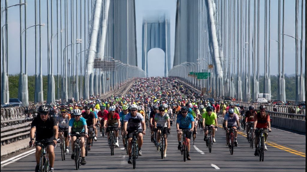 Group of cyclists navigating city streets during organized bike tour with route markers