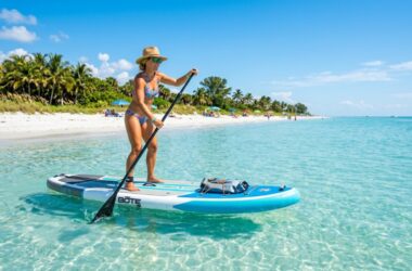 Paddler on an inflatable SUP board in calm Florida coastal waters.